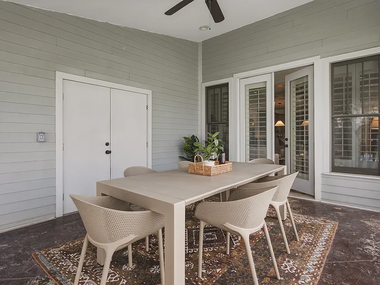 Indoor sun porch with dining table for 6, leading outside to the fenced-in yard.