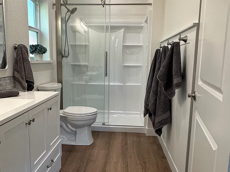 Beautiful spacious bathroom with glass shower door.