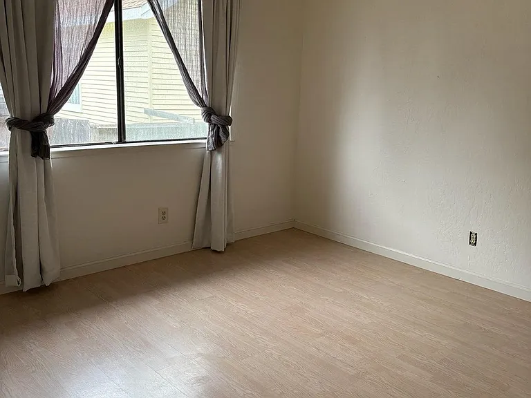 Large master bedroom includes plank flooring, full closet and large picture window