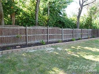 Fenced backyard with attractive landscaping and shade trees.