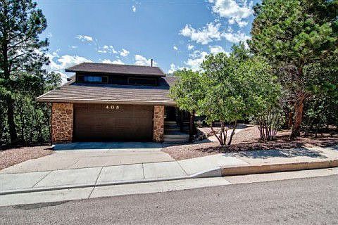 Two car garage with opener and extra parking on side of home