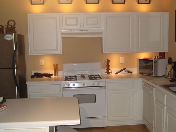 Cozy kitchen with under and above cabinet lighting and island-style counter