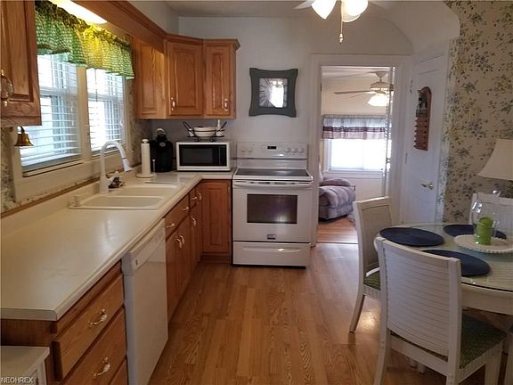 Kitchen with oak cabinetry leading from the dining room.