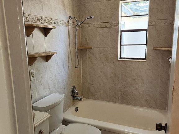 Bathroom tiled from floor to ceiling,marble soap dishes and holders
