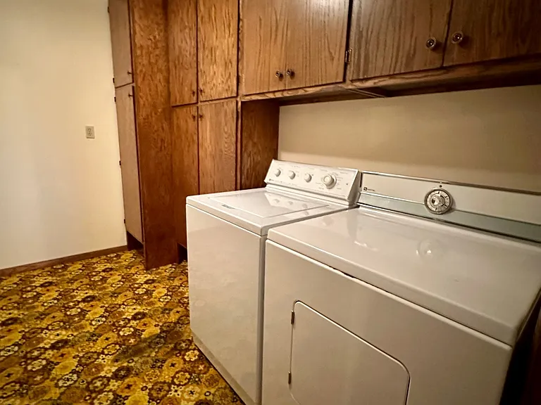 Convenient laundry and utility room featuring washer and dryer as well as ample space for storage and organization.