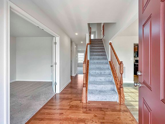 Foyer entry - hardwood flooring and carpeted stairs