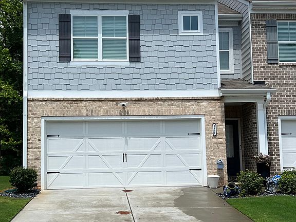 Front of home with garage. Front door entry to right.