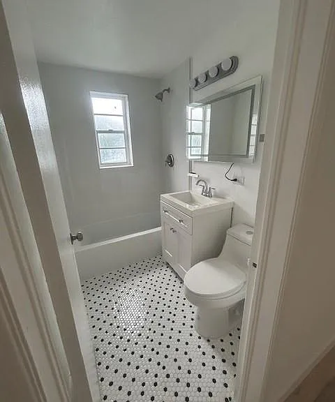 amazing designer bath with nickel polished fixtures and vanity with single piece toilet