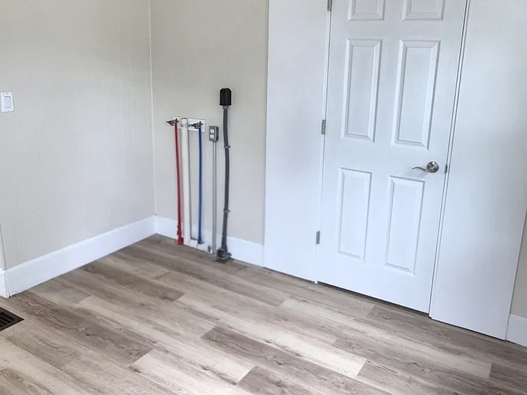 Laundry hook ups and doorway into 3rd bedroom