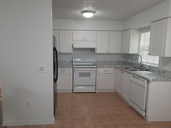 Kitchen with refrigerator, dishwasher, and electric stove.