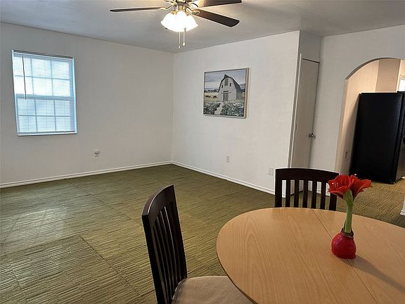 Spacious room featuring green patterned carpeting and white painted walls