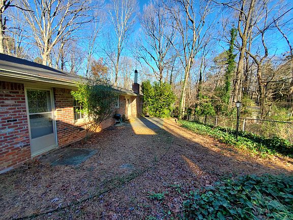 Level, fenced backyard nestled in woods.