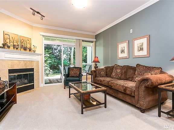 The living room is large with a cozy natural gas fireplace and the slider is access to the private back patio looking over the manicured and well maintained grounds.  