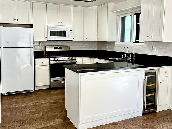 Kitchen with custom cabinets, granite counters, new stainless steel range oven, dishwasher, wine refrigerator