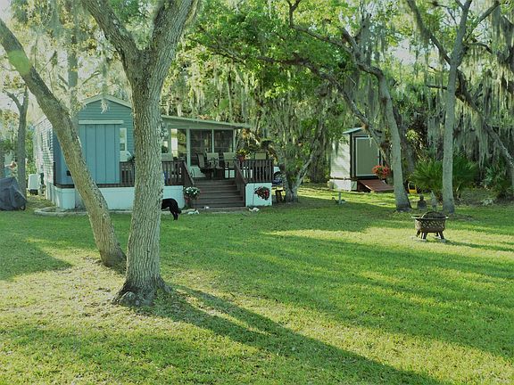 Rear of home with large, shaded lot. Two sheds.