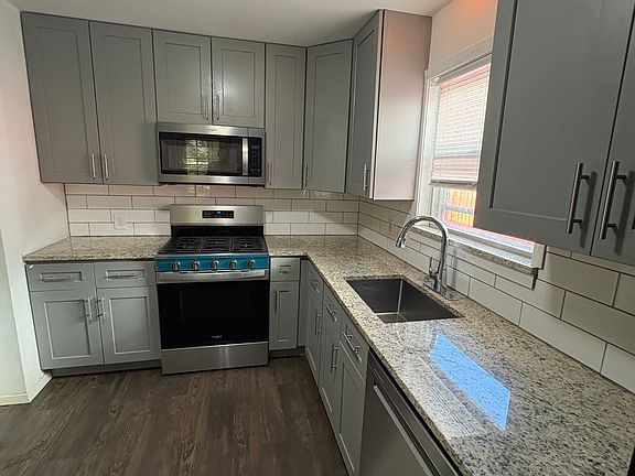 Fully remodeled kitchen features Whirlpool appliances, granite counters, beautiful gray cabinetry with soft close doors and drawers
