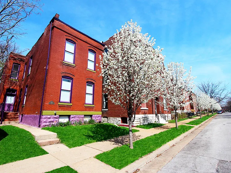 A picturesque spring streetscape on Indiana Avenue, lined with historic brick homes and flowering trees.