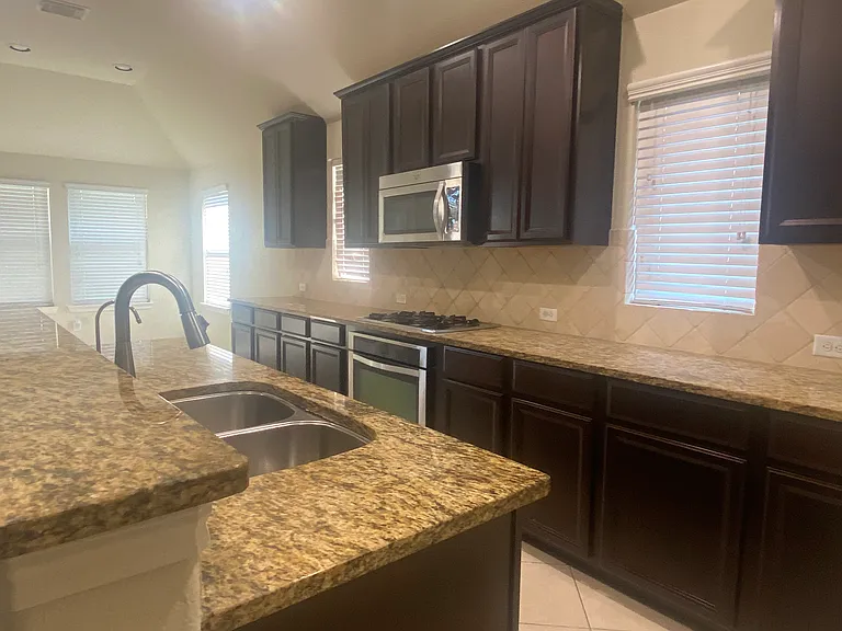 Beautiful open kitchen featuring granite countertops and abundant cabinet space _ perfect for cooking and entertaining.