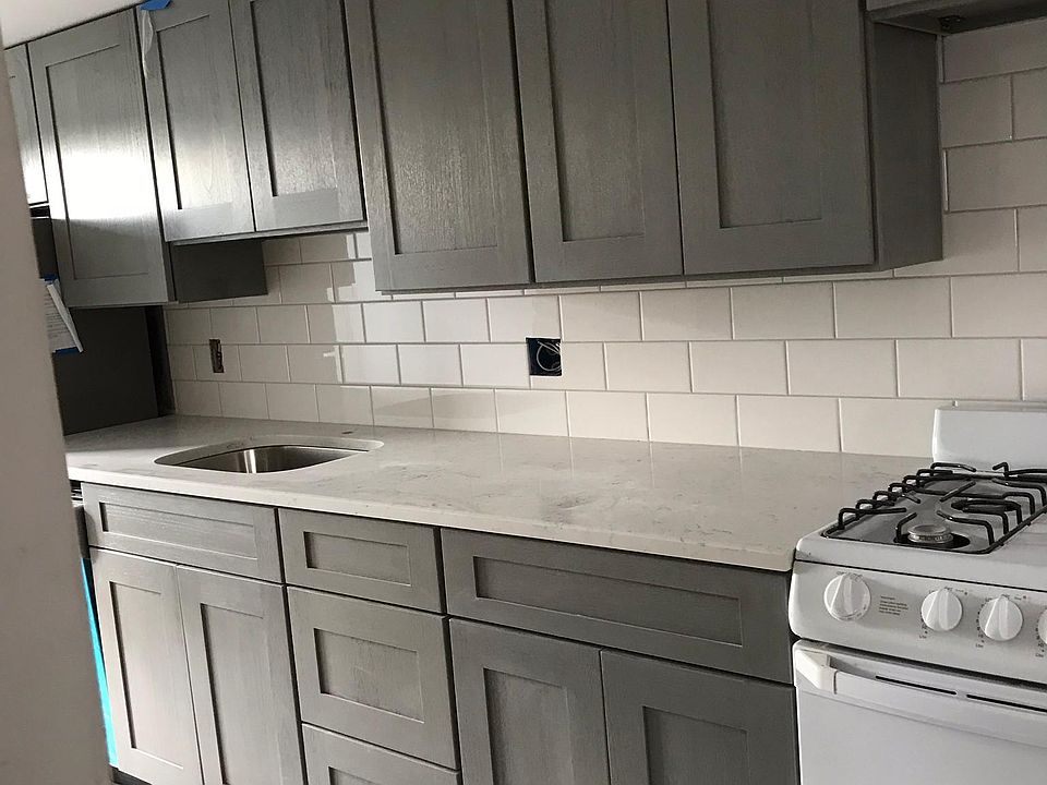 taken before we finished- nice simple quartz top, tile backsplash, ceramic tile floor, new stove, new stainless refrigerator, new dishwasher, garbage disposal,