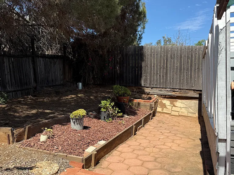 Paved outdoor patio area and fenced yard.