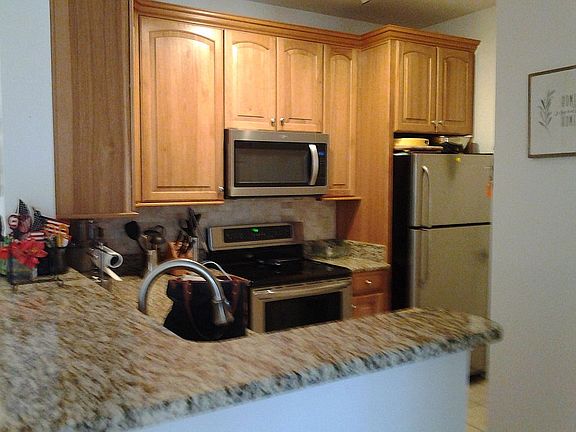 Kitchen with granite countertops, microwave, dishwasher, disposal, utility room with washer and dryer.