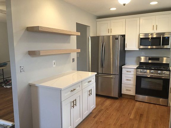 Kitchen w floating shelves and prep area.