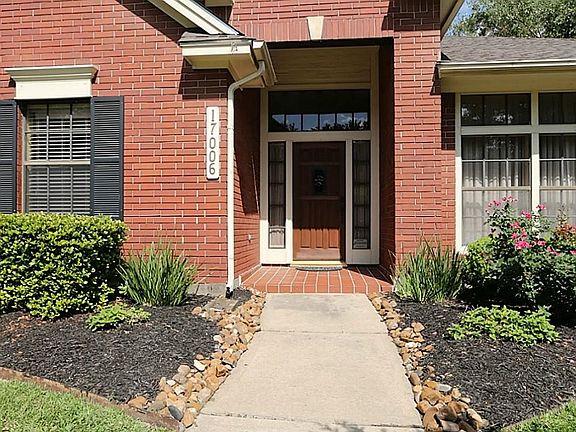 This rich red brick home features a spacious covered front porch, professional landscaping and a spr