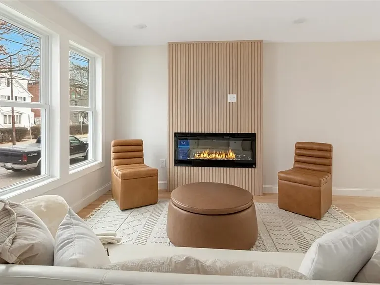 Sun-drenched living area with oversized windows and high-end modern finishes.