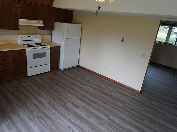 Large kitchen with an opening leading to a grand, semi-open living space.