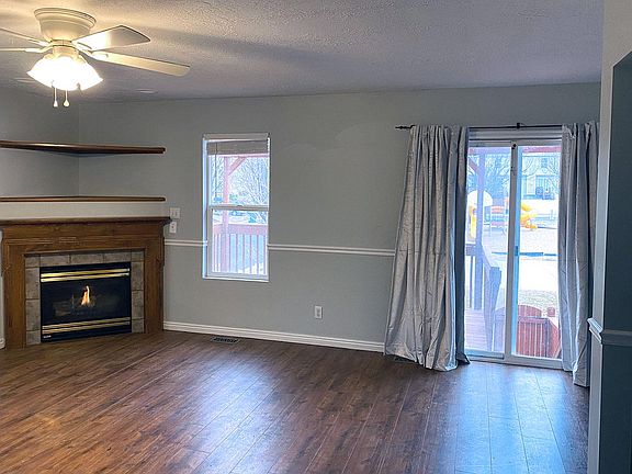 Living room with gas fireplace and views of playground & basketball court.