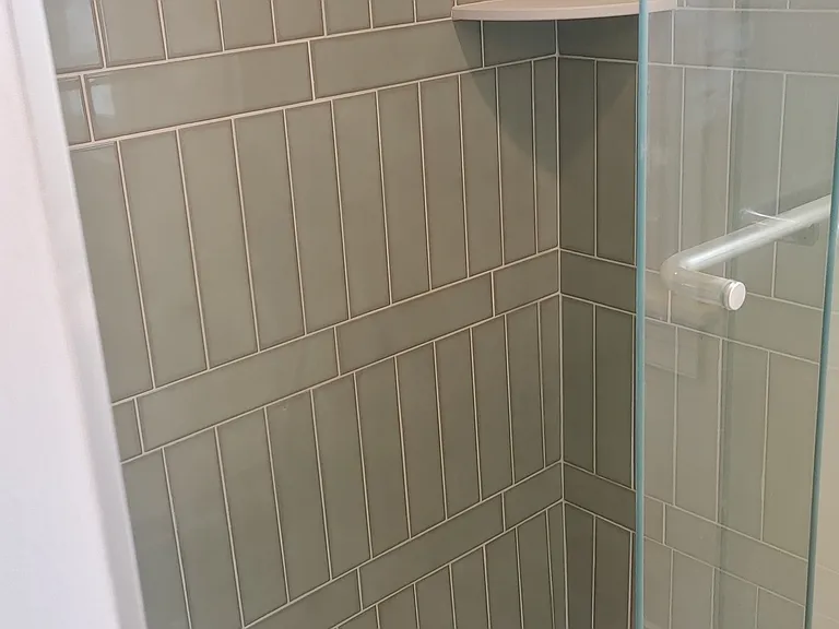 Walk in shower with gorgeous sage-colored tile.