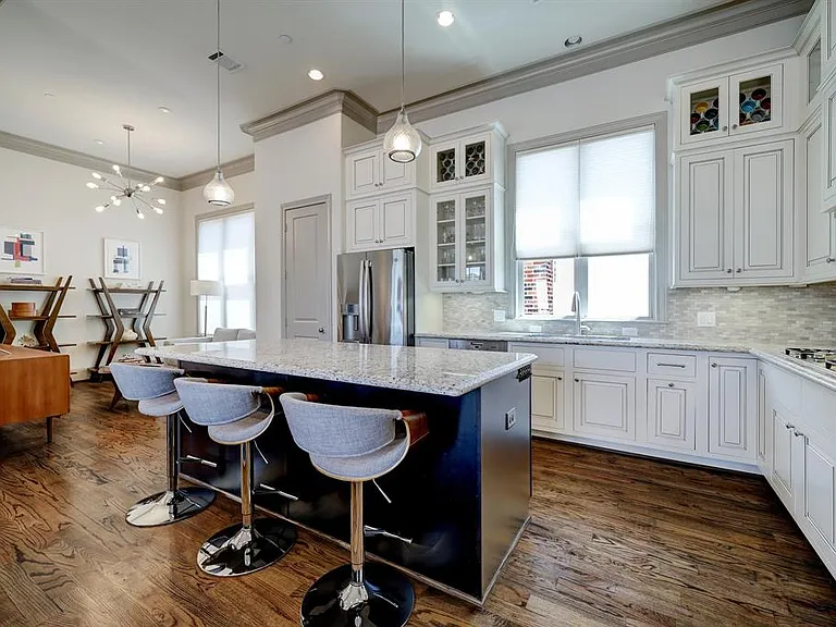 The fabulous kitchen features an oversized island, Miele stainless steel oven, microwave, 5-burner gas cooktop, dishwasher, and vent hood, GE stainless steel refrigerator, and abundant storage / counter space.
