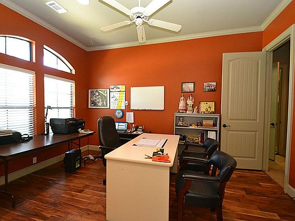 Double doors open to the study accented by hand scraped hardwood floors, ceiling fan and crown moldi