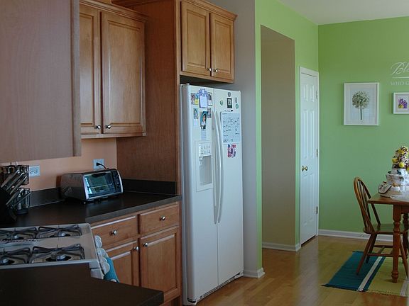 Spacious kitchen with tall maple cabinets and hardwood floors