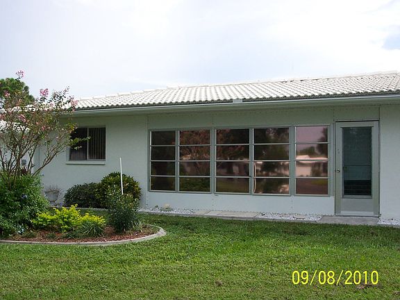 Rear Elevation with flower bed and view of backyard