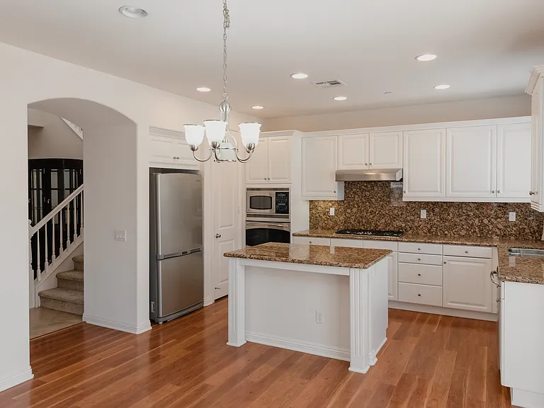 Kitchen with island and stainless steel appliances and view of stairs