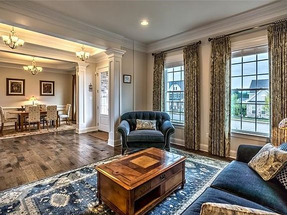 The living room and dining room are found adjacent to the foyer, brightened by large windows and providing lovely spaces for hos