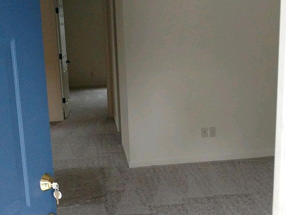 Living room with ceiling fan with brand new carpet.