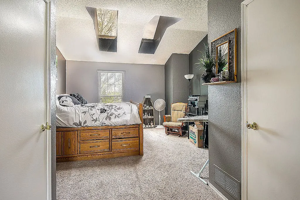 Upstairs master bedroom with vaulted ceiling and skylight - 6758 S Independence St