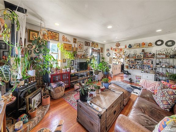 Bright living room with wood-burning stove & recessed lighting.