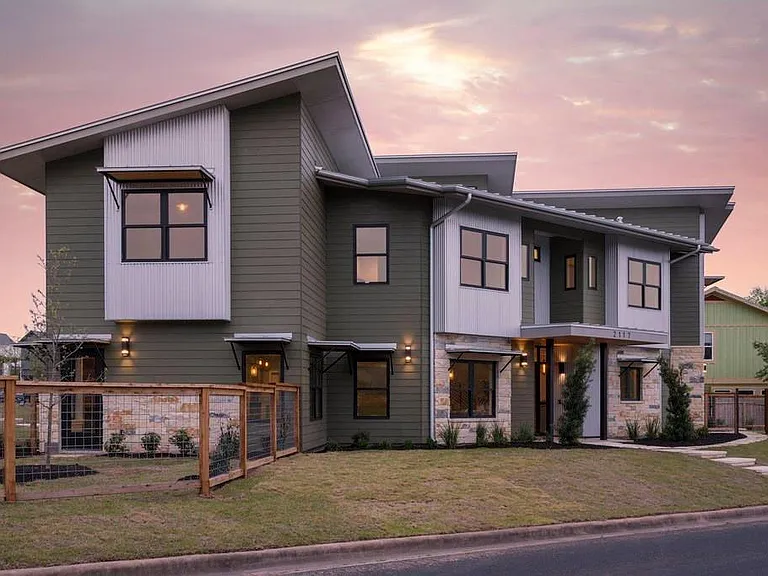 This stunning contemporary home showcases exceptional curb appeal with a durable metal roof, striking architectural lines, and a sophisticated blend of stone, siding, and modern design elements.