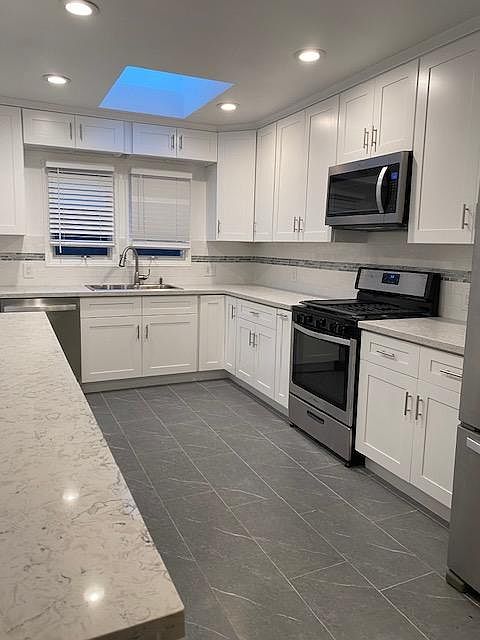 newly remodeled kitchen with lots of cabinets, ample counter tops and skylight