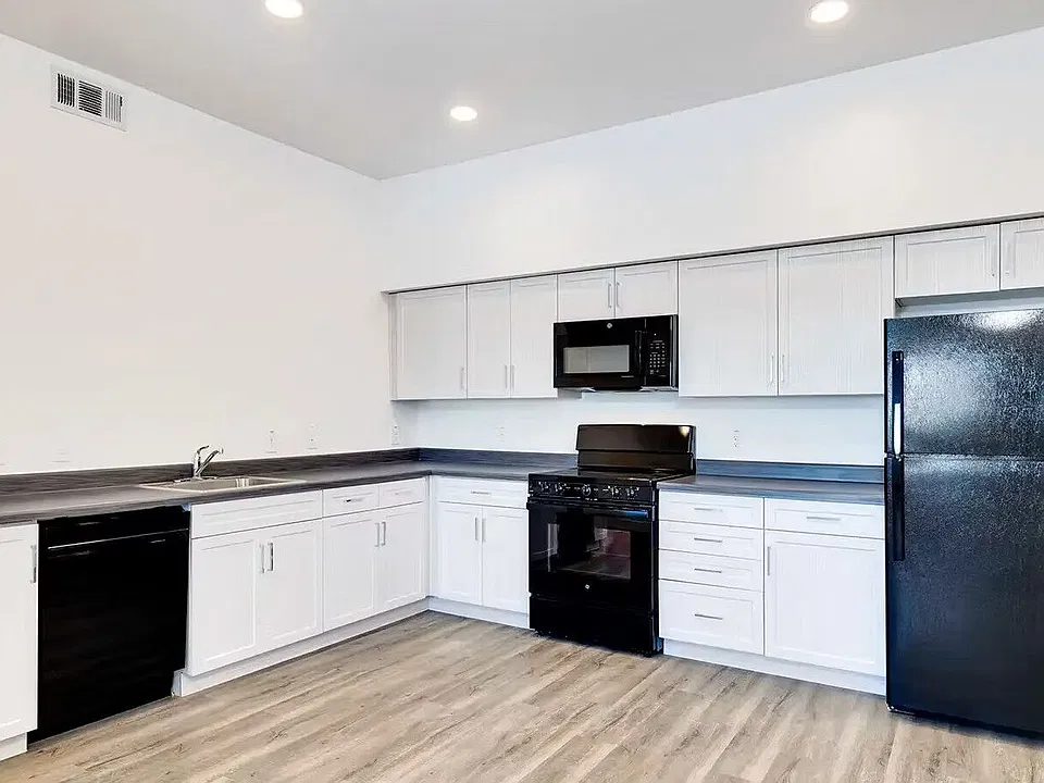 Kitchen with black appliances and white cabinets