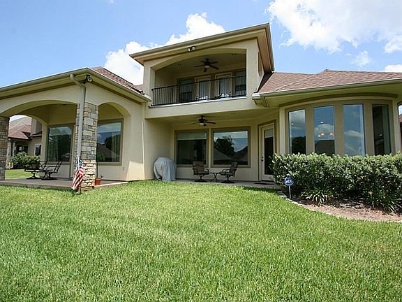 Back of the property showing all the covered patio and balcony areas taken from the lakeside.