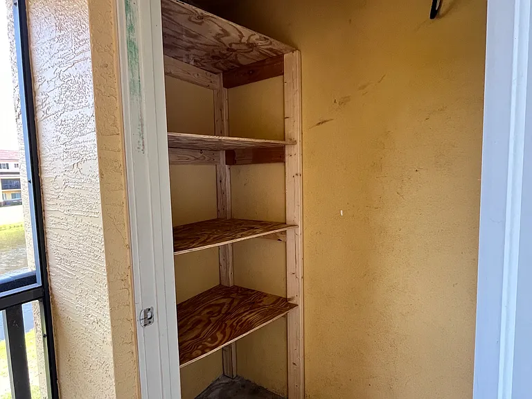 Storage closet on patio with shelves