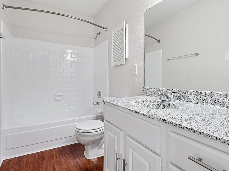 Modern bathroom featuring a sleek countertop, white cabinetry, and a pristine bathtub with polished fixtures. Modern bathroom featuring a sleek countertop, white cabinetry, and a pristine bathtub with polished fixtures.