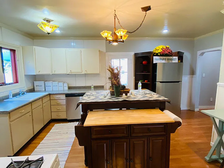 The kitchen from the bathroom view shows the side deck door and the arched hall doorway.