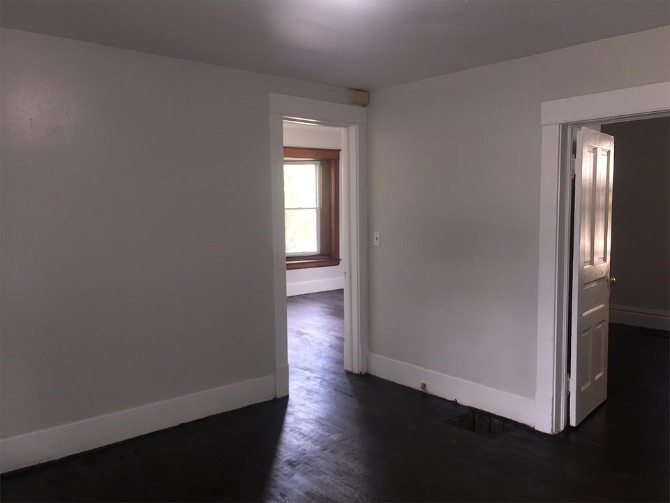 View of living room, looking into bedrooms. Original hardwood floors are refinished throughout.
