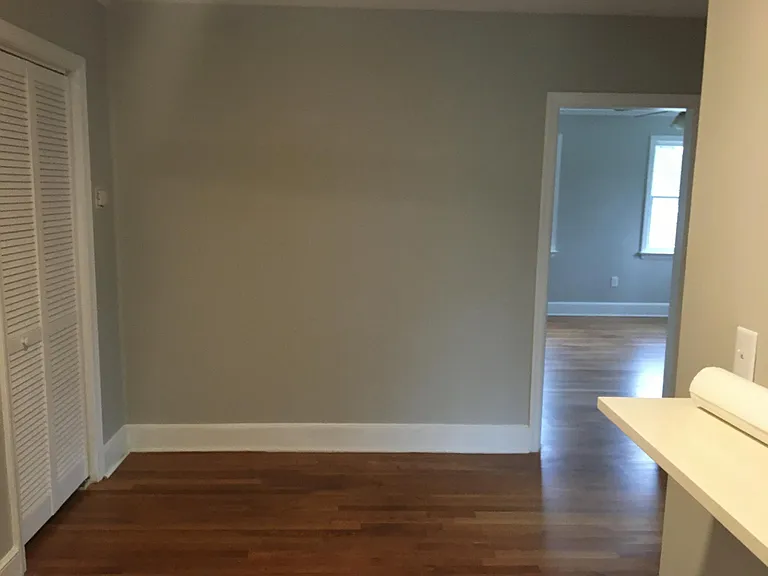 Gorgeous refinished mid century wood floors Dining area holds full dining table and chairs.
