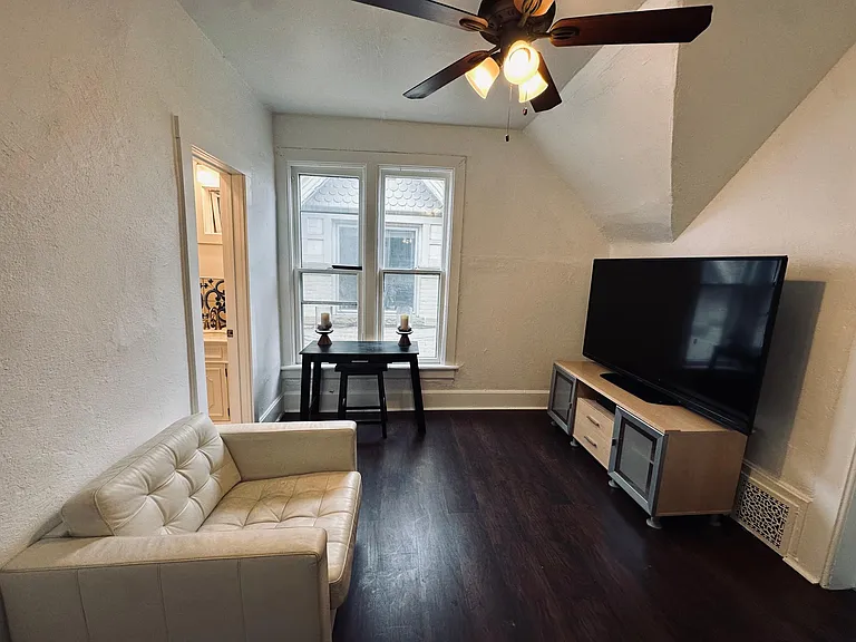 Living room view. Left bathroom door. Laminate wood floors.
North facing window
